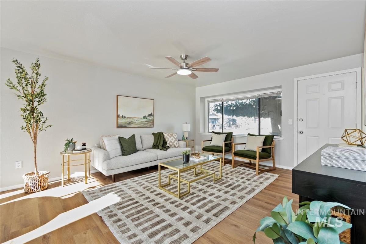 Living room featuring ceiling fan and light wood-style flooring