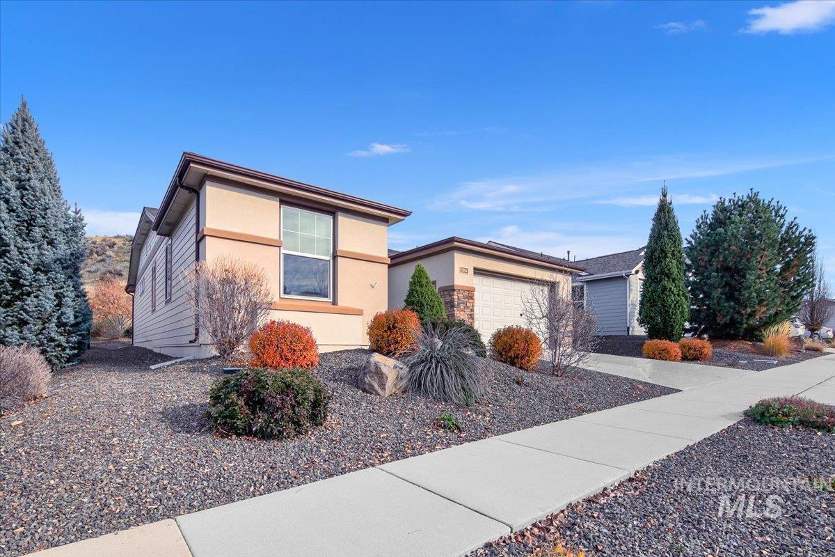 View of front facade featuring stucco siding, concrete driveway, and a garage