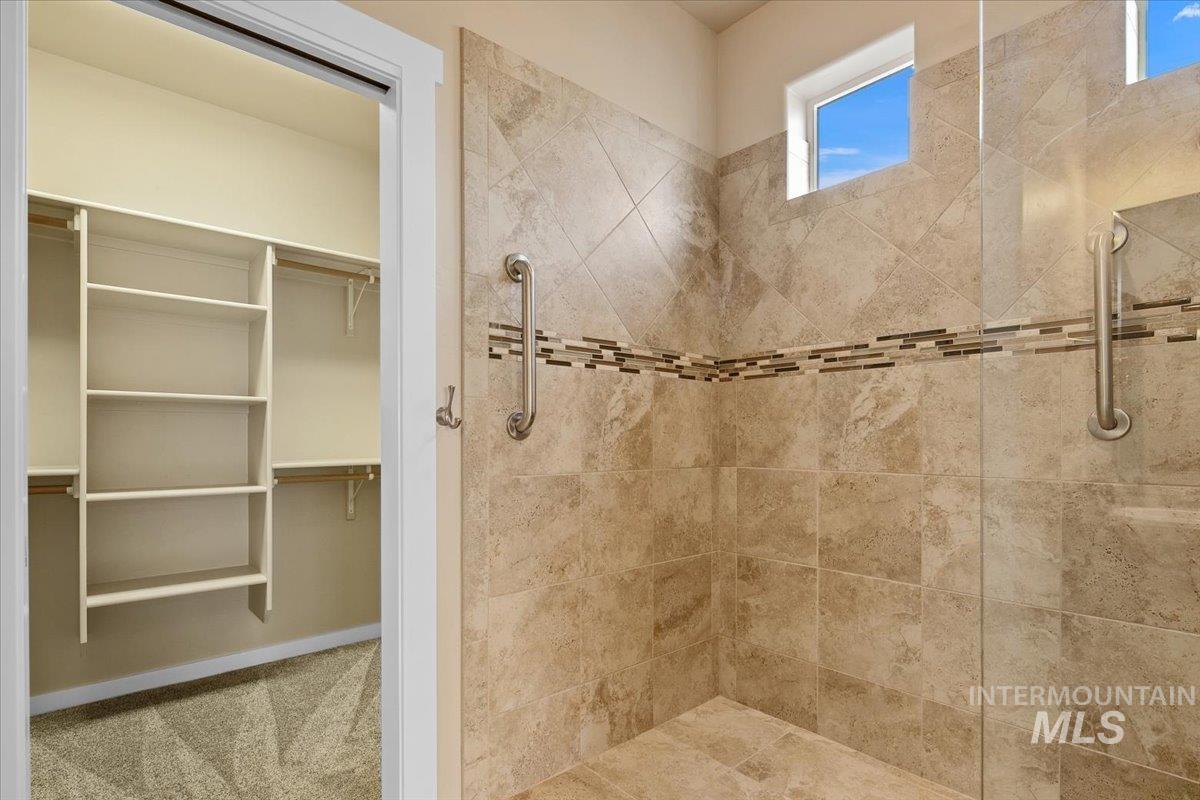 Full bath with carpet flooring and tiled shower