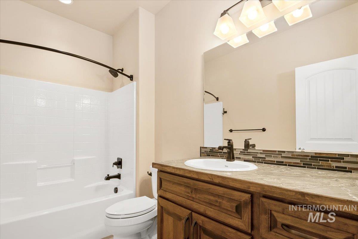 Hall Bathroom with shower / tub combination, vanity, and tasteful backsplash