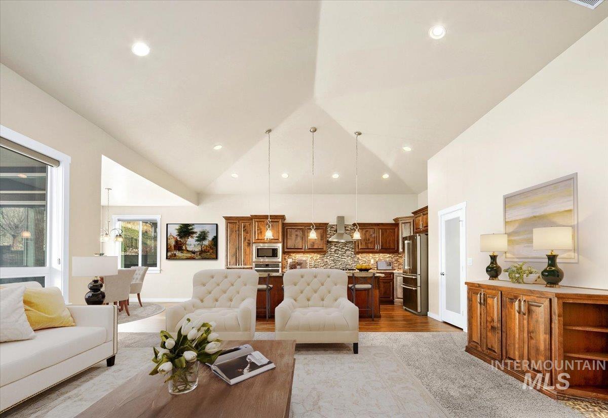 Living area with light wood-style flooring and high vaulted ceiling