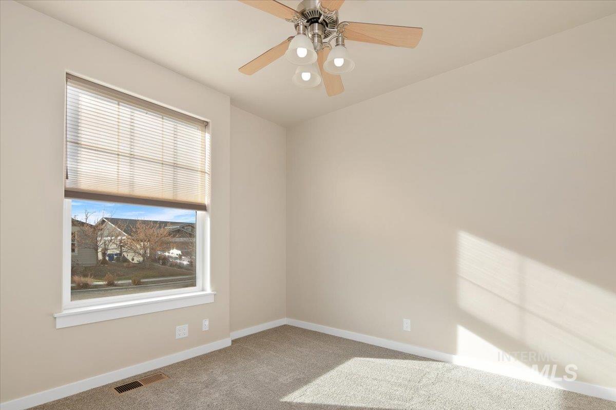 Front of home bedroom with ceiling fan with light.
