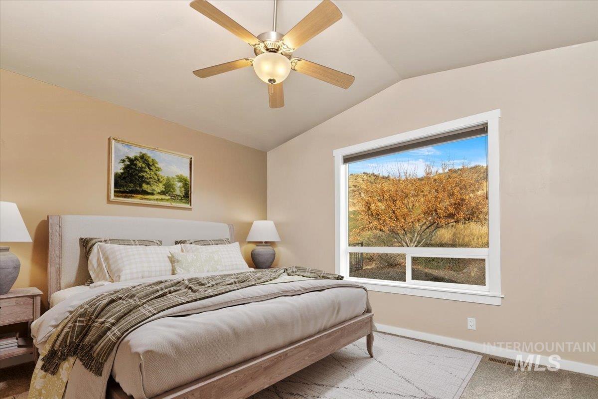 Primary Suite featuring vaulted ceiling, ceiling fan, and new carpet