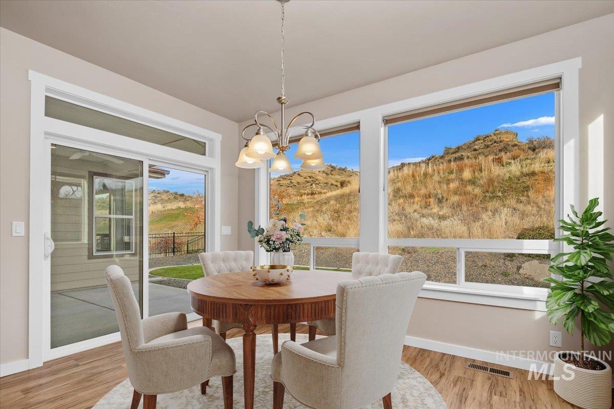Dining room with wood finished floors, a chandelier, and a mountain view
