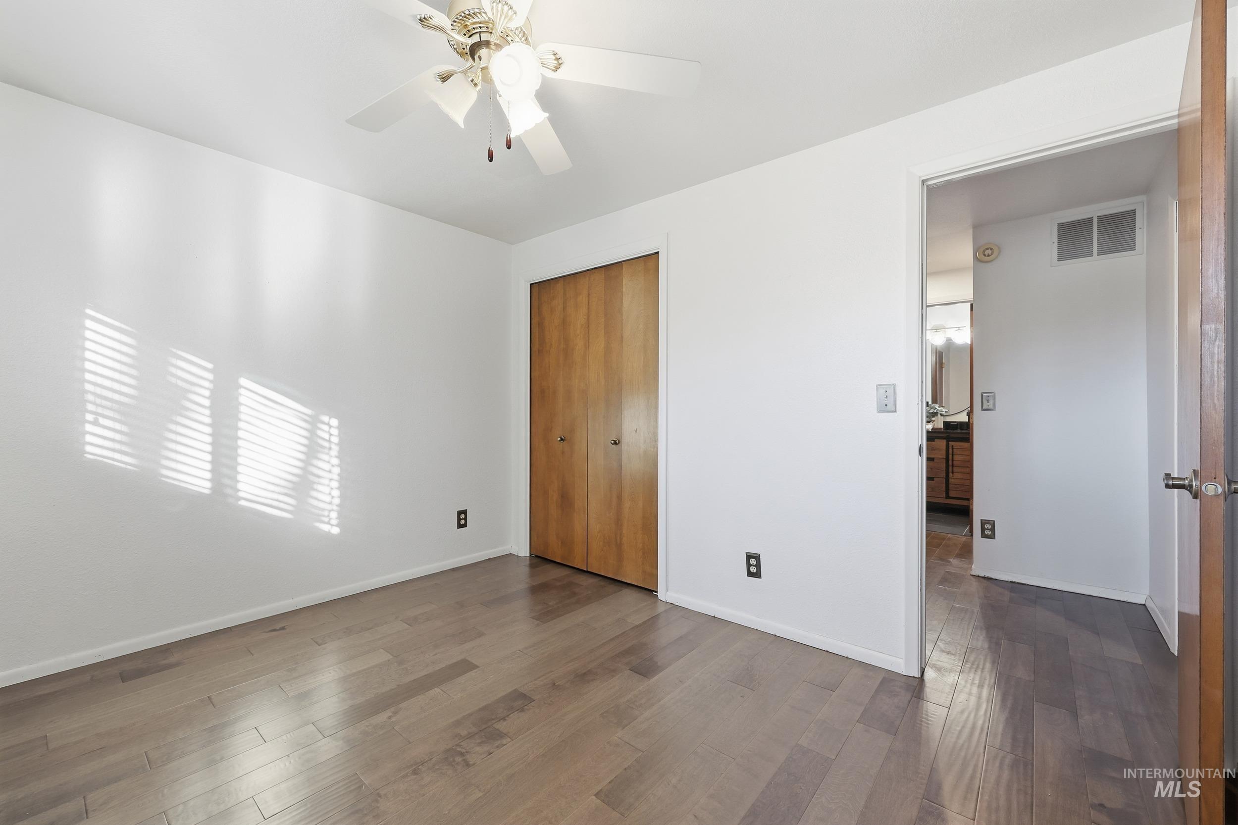 Bedroom #3 featuring engineered wood floors, a closet, a ceiling fan, and a large closet.