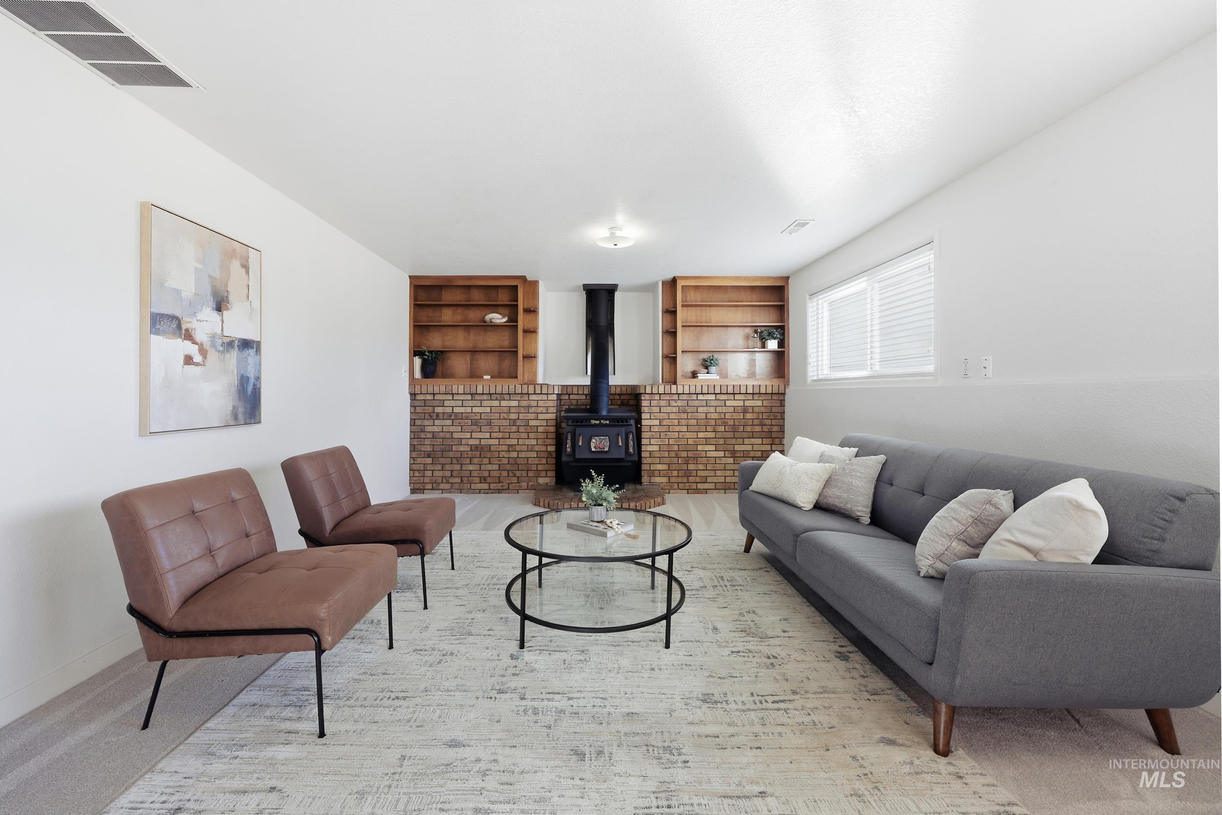 Family room area featuring a wood stove and built in features with outlets.