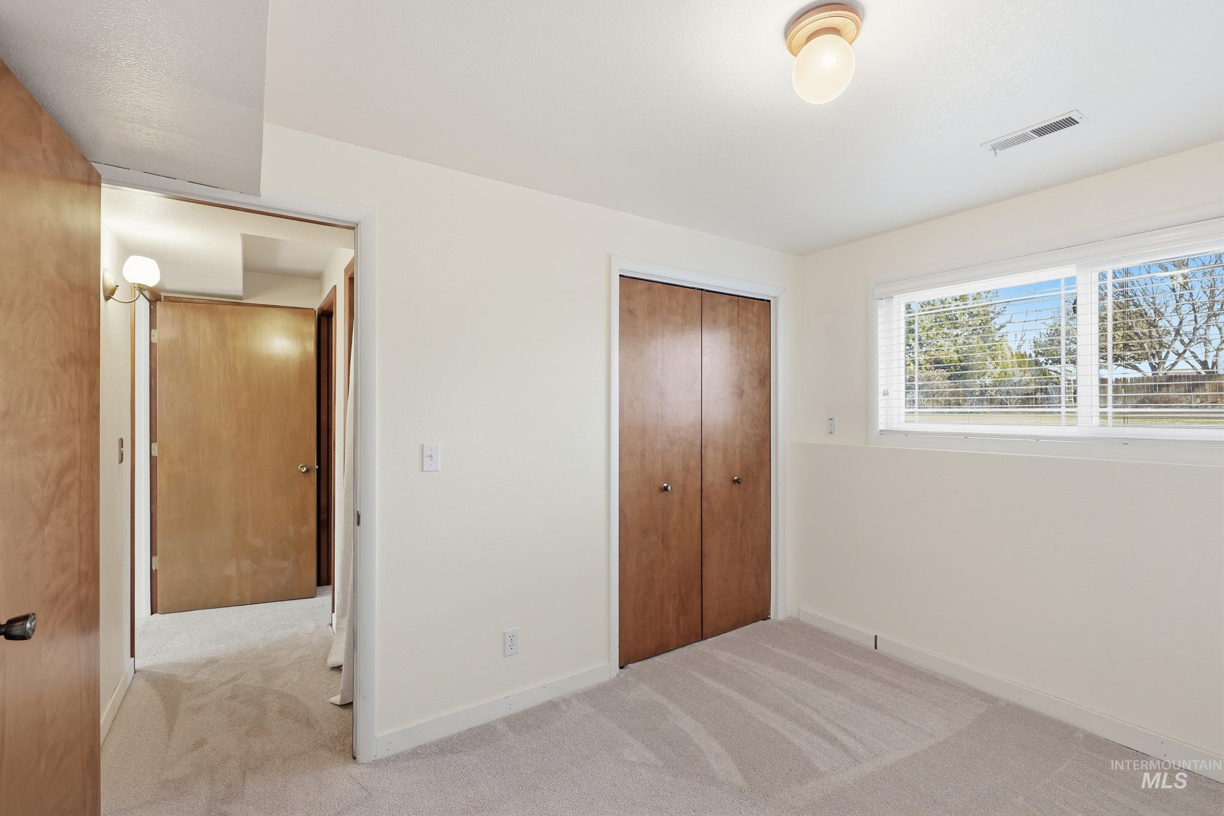 Bedroom #4 with new carpet flooring and lots of light.