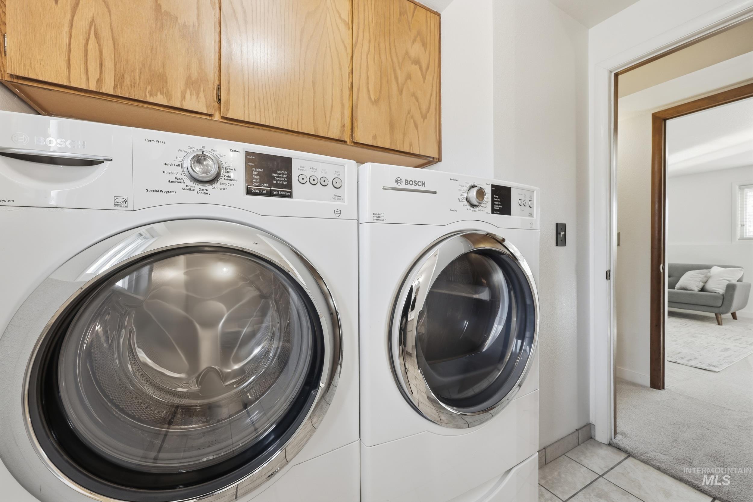 Laundry room featuring washer and clothes dryer, and a good amount of cabinet space.