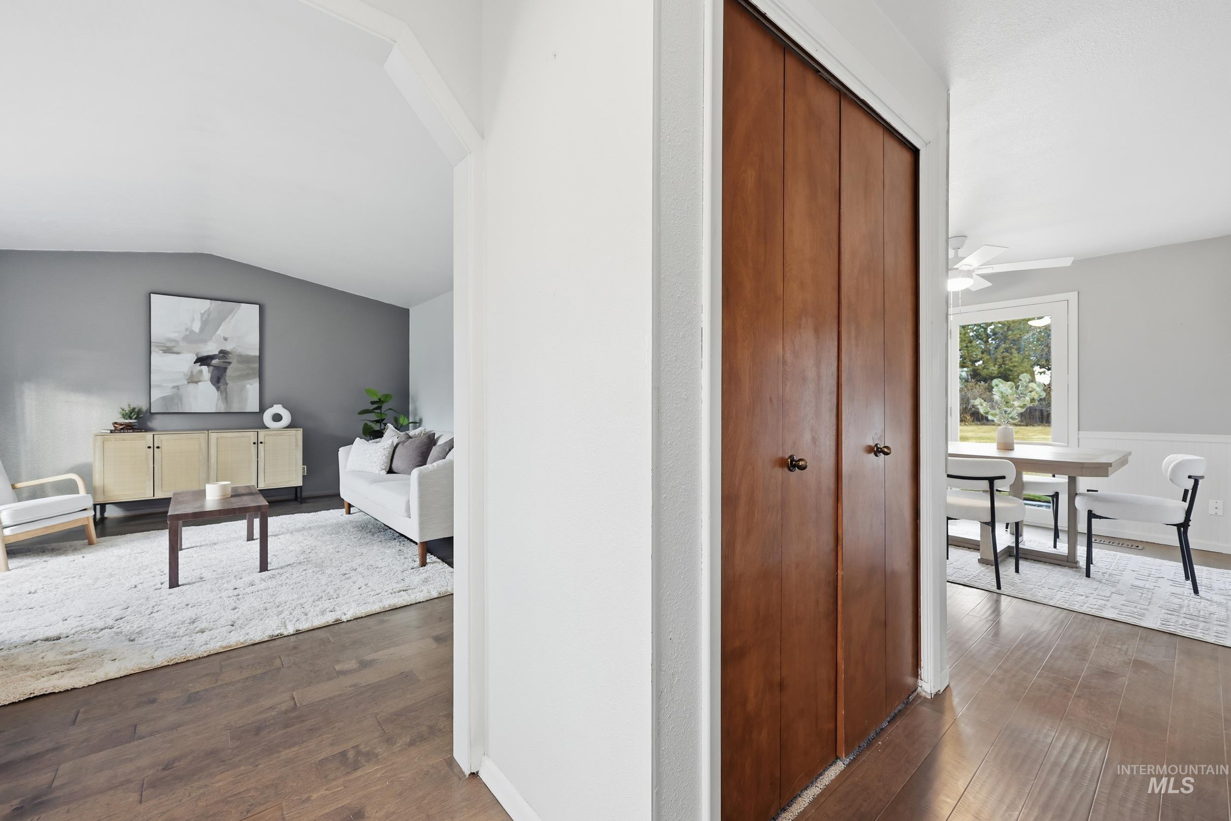 Hallway featuring new engineered hardwood flooring and lofted ceiling.