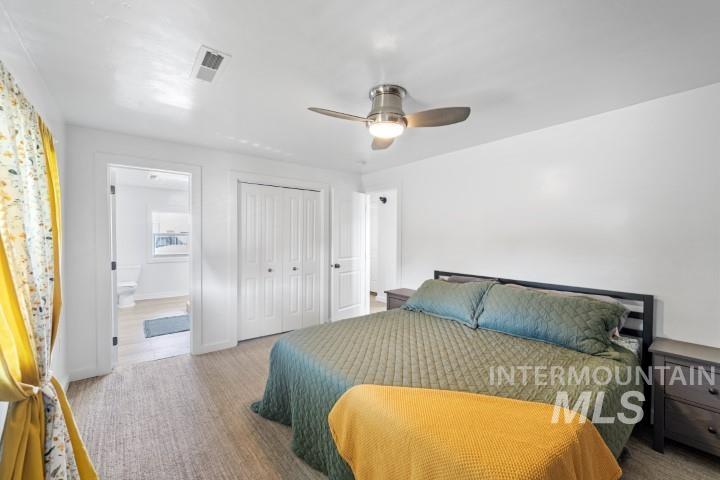 Bedroom with a closet, ceiling fan, and ensuite bath