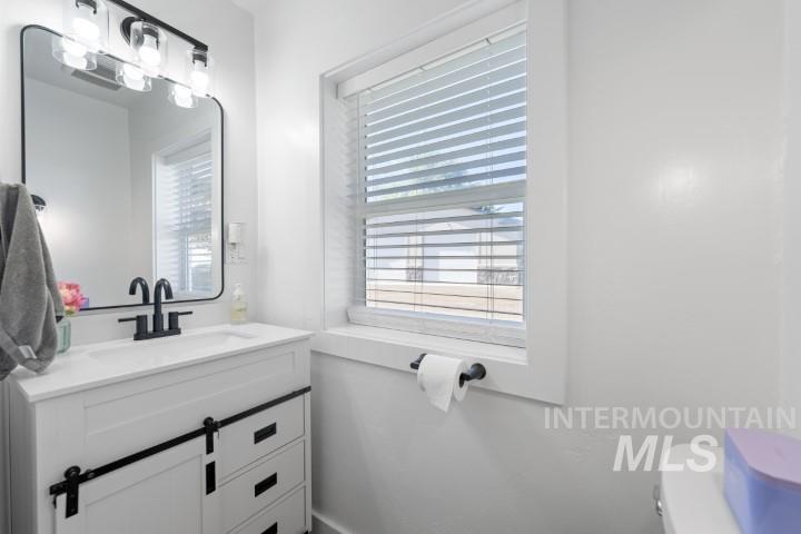 Half bathroom with healthy amount of natural light and vanity