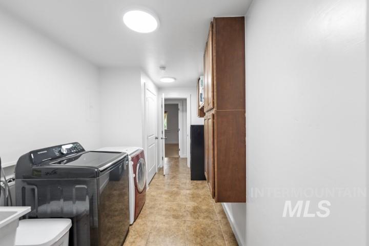Laundry area with washer and dryer and light tile patterned floors