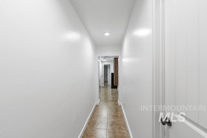 Corridor with light tile patterned floors and recessed lighting