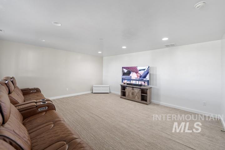 Unfurnished living room with light carpet and recessed lighting