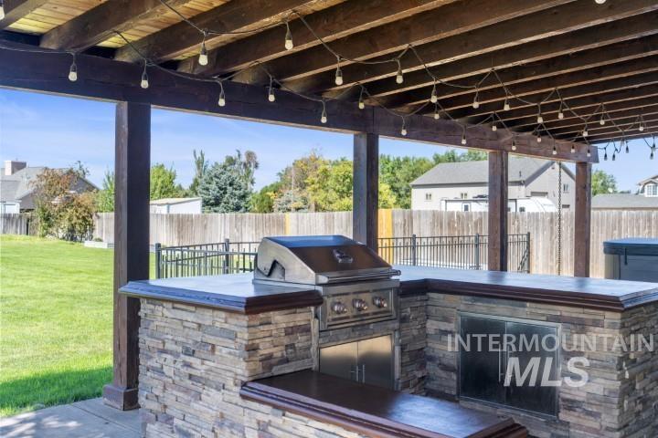 Fenced backyard featuring an outdoor kitchen and a patio area