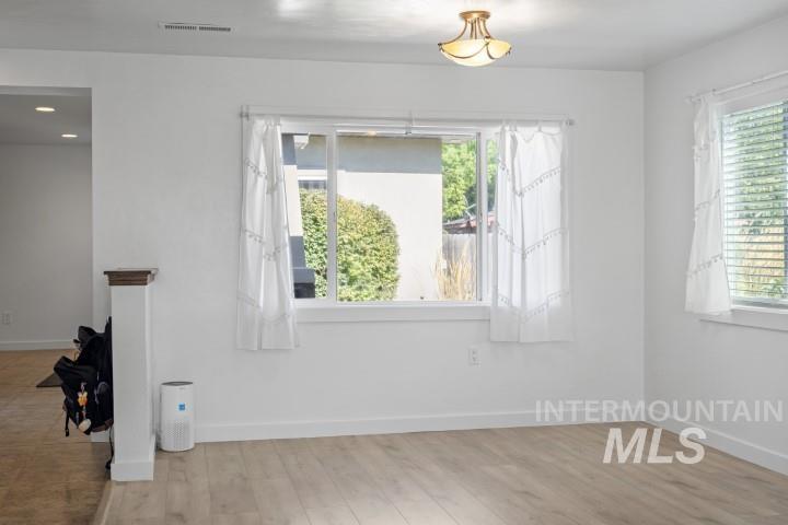 Empty room featuring baseboards and light wood finished floors