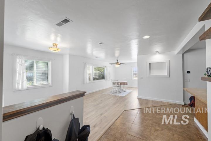 Unfurnished living room with tile patterned floors and ceiling fan