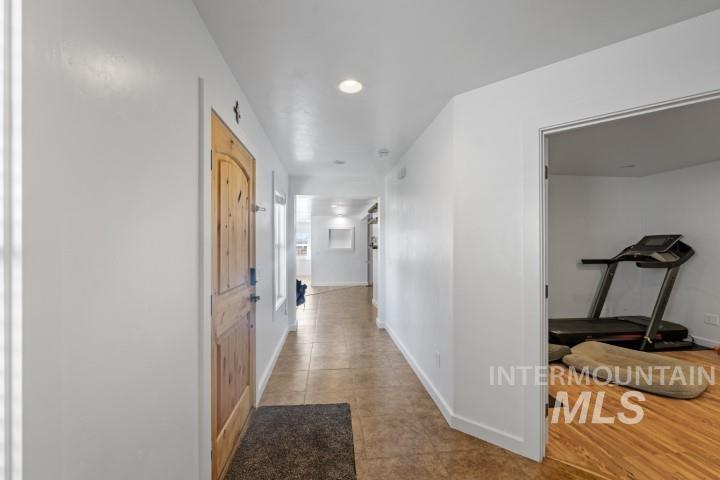 Hall featuring light tile patterned floors and recessed lighting