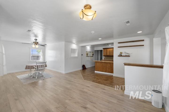Unfurnished living room with light wood-style flooring, ceiling fan, and recessed lighting