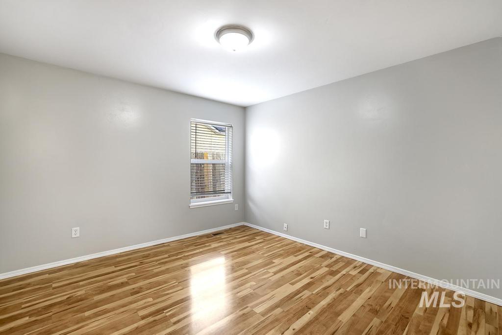 Spare room featuring wood finished floors and baseboards