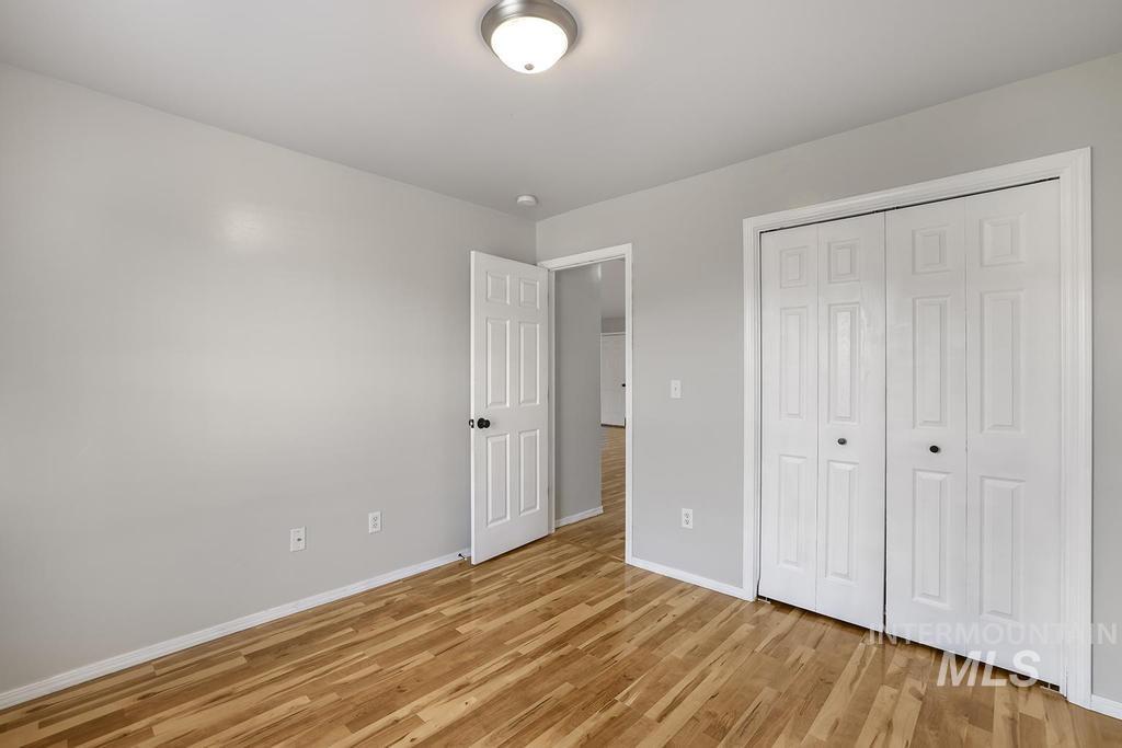 Unfurnished bedroom with light wood-type flooring and a closet