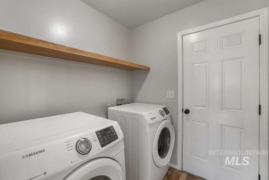Laundry area featuring independent washer and dryer and wood finished floors