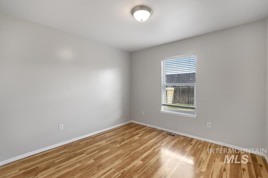 Unfurnished room with baseboards and light wood-style flooring