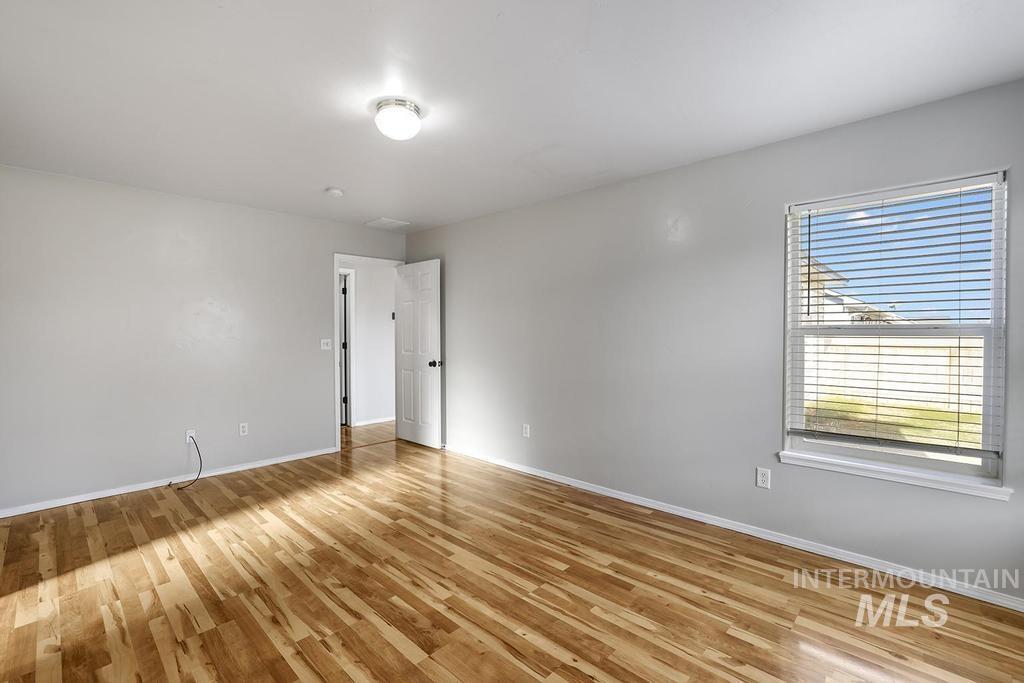Empty room with light wood-style flooring and baseboards