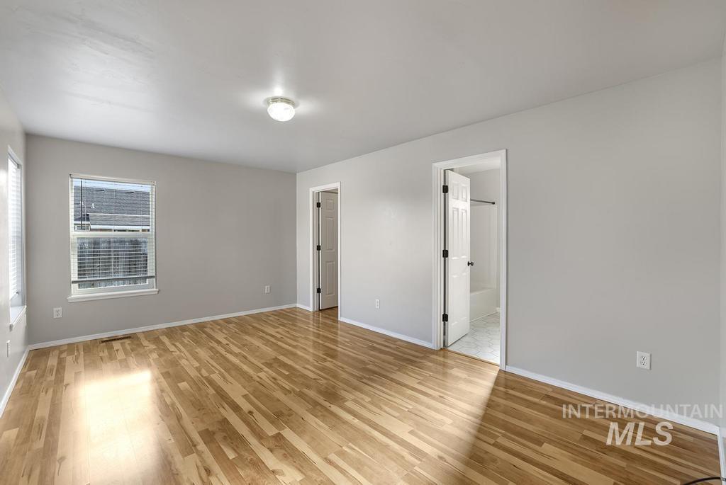 Unfurnished bedroom featuring light wood finished floors and baseboards