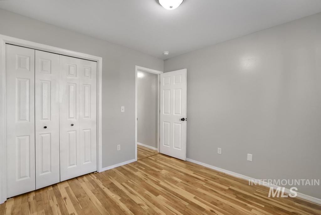 Unfurnished bedroom featuring light wood finished floors and a closet