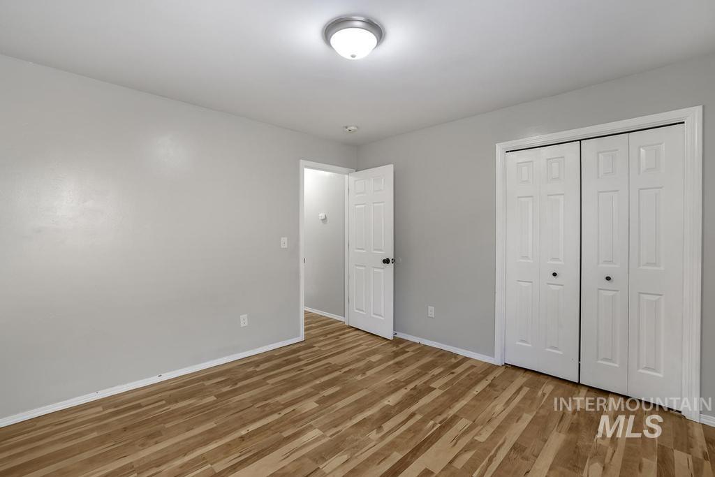 Unfurnished bedroom with light wood-type flooring and a closet