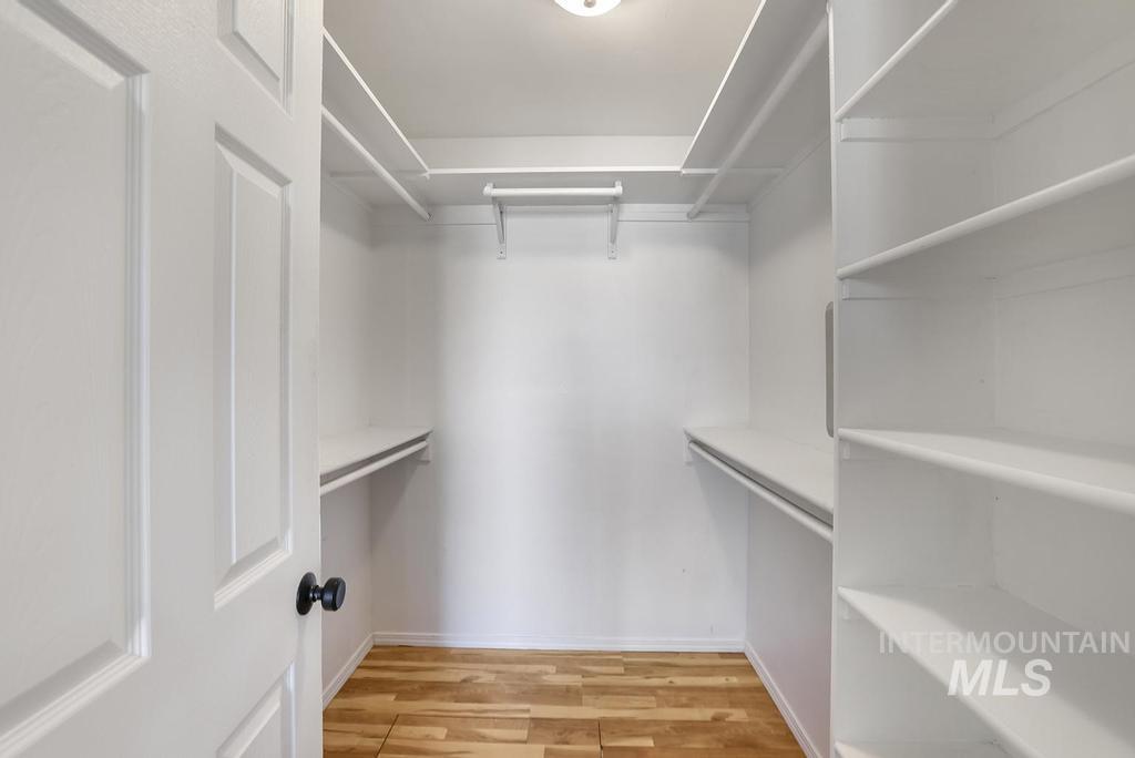Walk in closet with light wood-type flooring