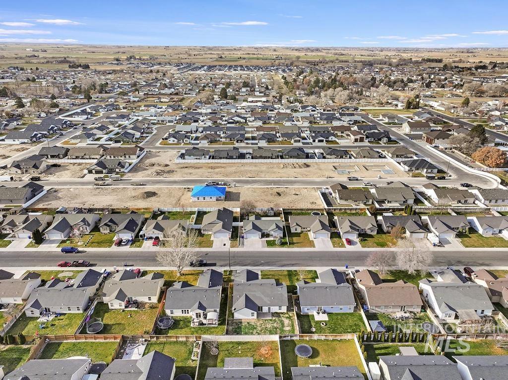 Aerial view of property and surrounding area with nearby suburban area