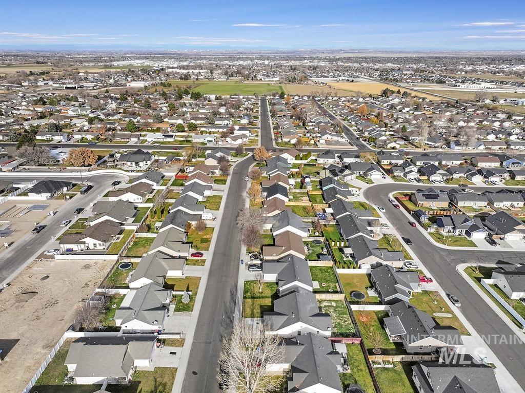 Aerial view of property and surrounding area with nearby suburban area