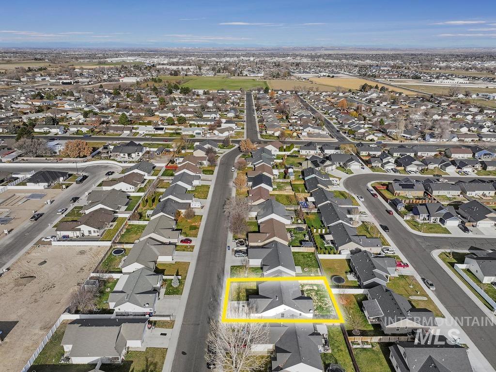 Aerial view of property and surrounding area featuring nearby suburban area and property parcel outlined