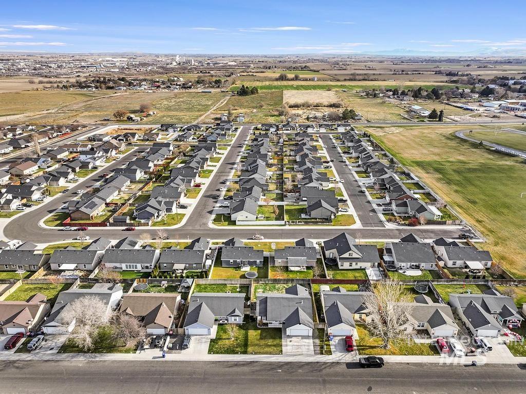 Aerial view of property and surrounding area featuring nearby suburban area