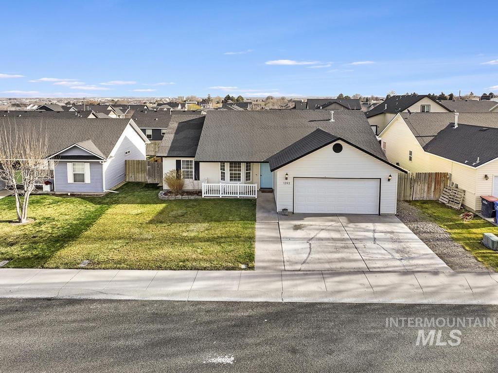 View of front of house featuring a residential view, concrete driveway, and an attached garage