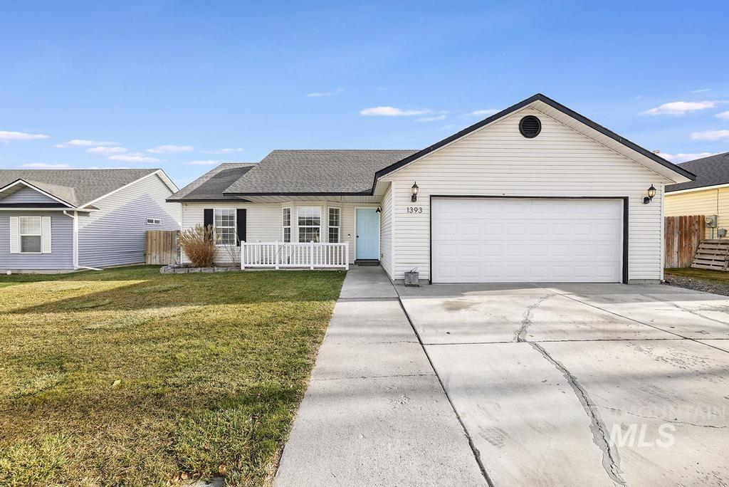 Ranch-style home with concrete driveway, a shingled roof, and an attached garage