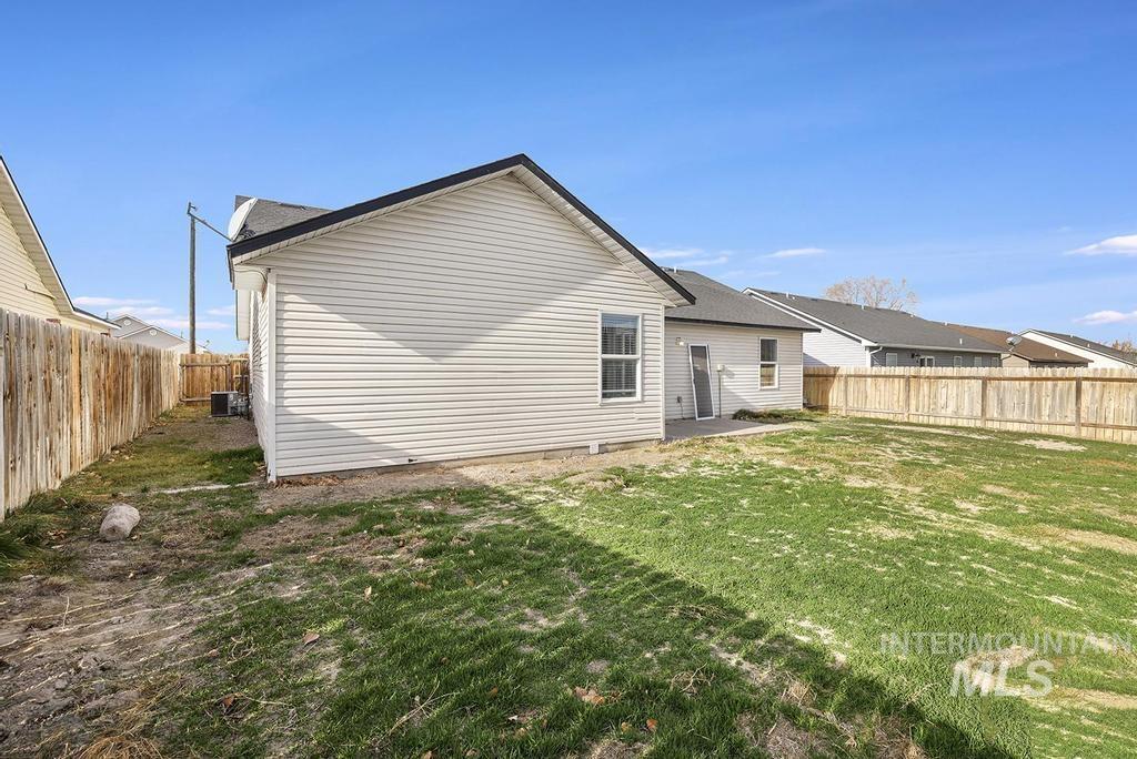Rear view of house featuring a fenced backyard