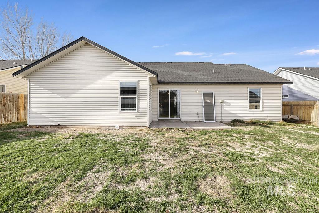 Back of property featuring a patio area and roof with shingles