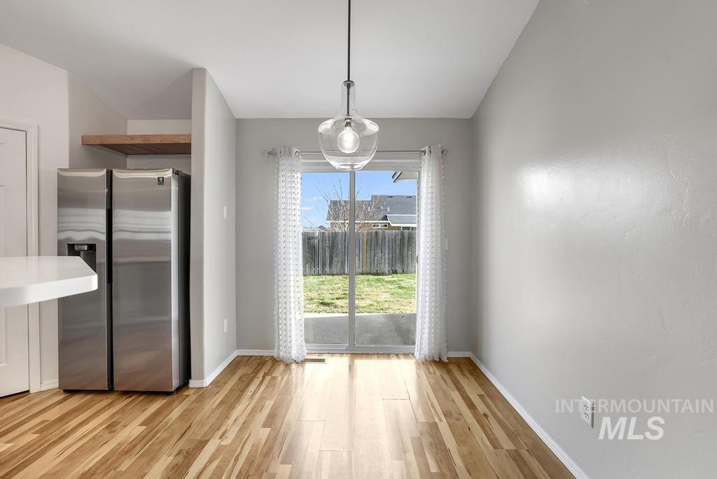 Unfurnished dining area with light wood finished floors and baseboards