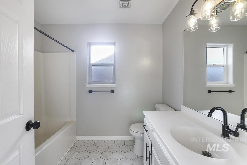 Full bathroom featuring vanity, light tile patterned flooring, and shower / tub combination
