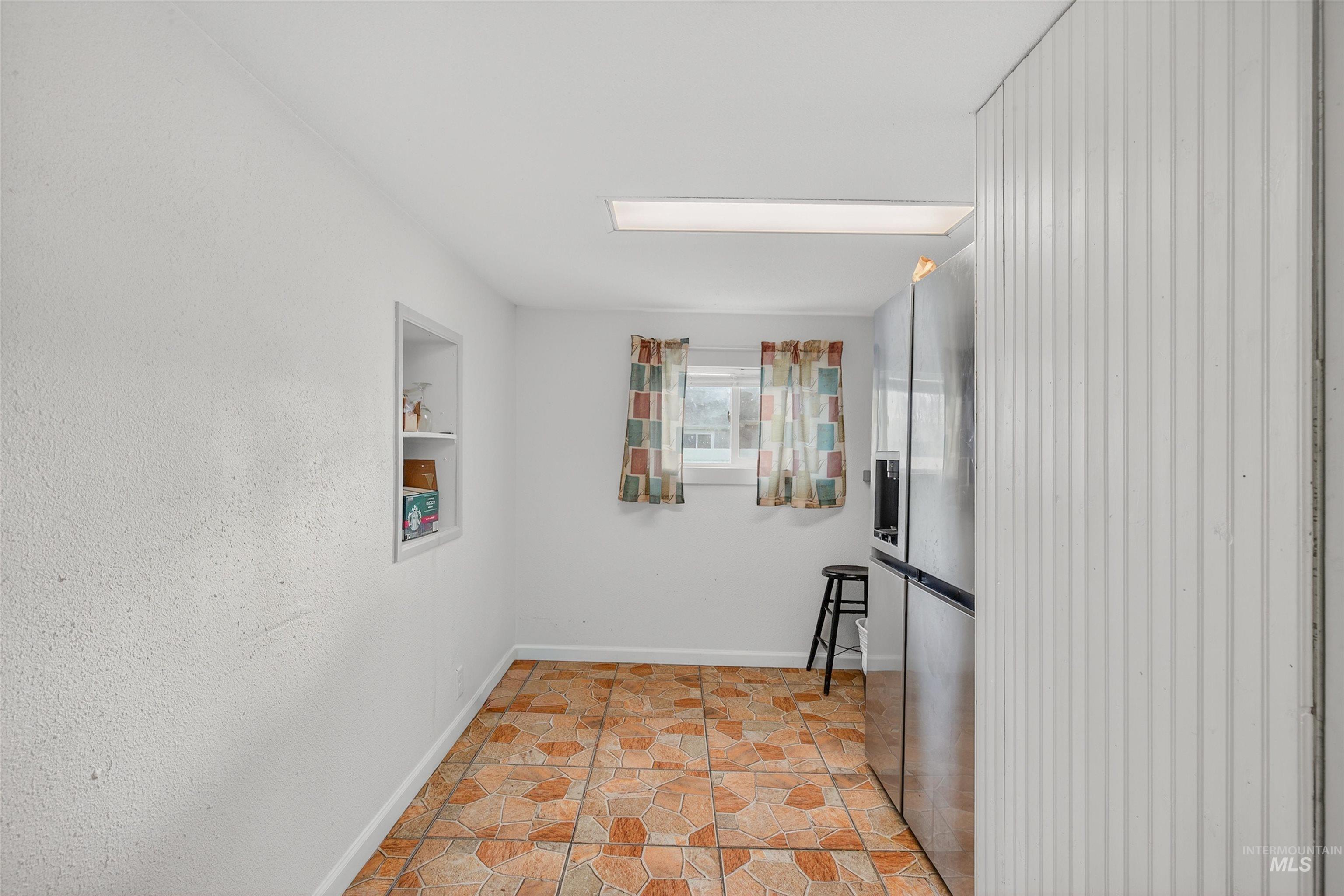 Hallway with stone finish floors and baseboards