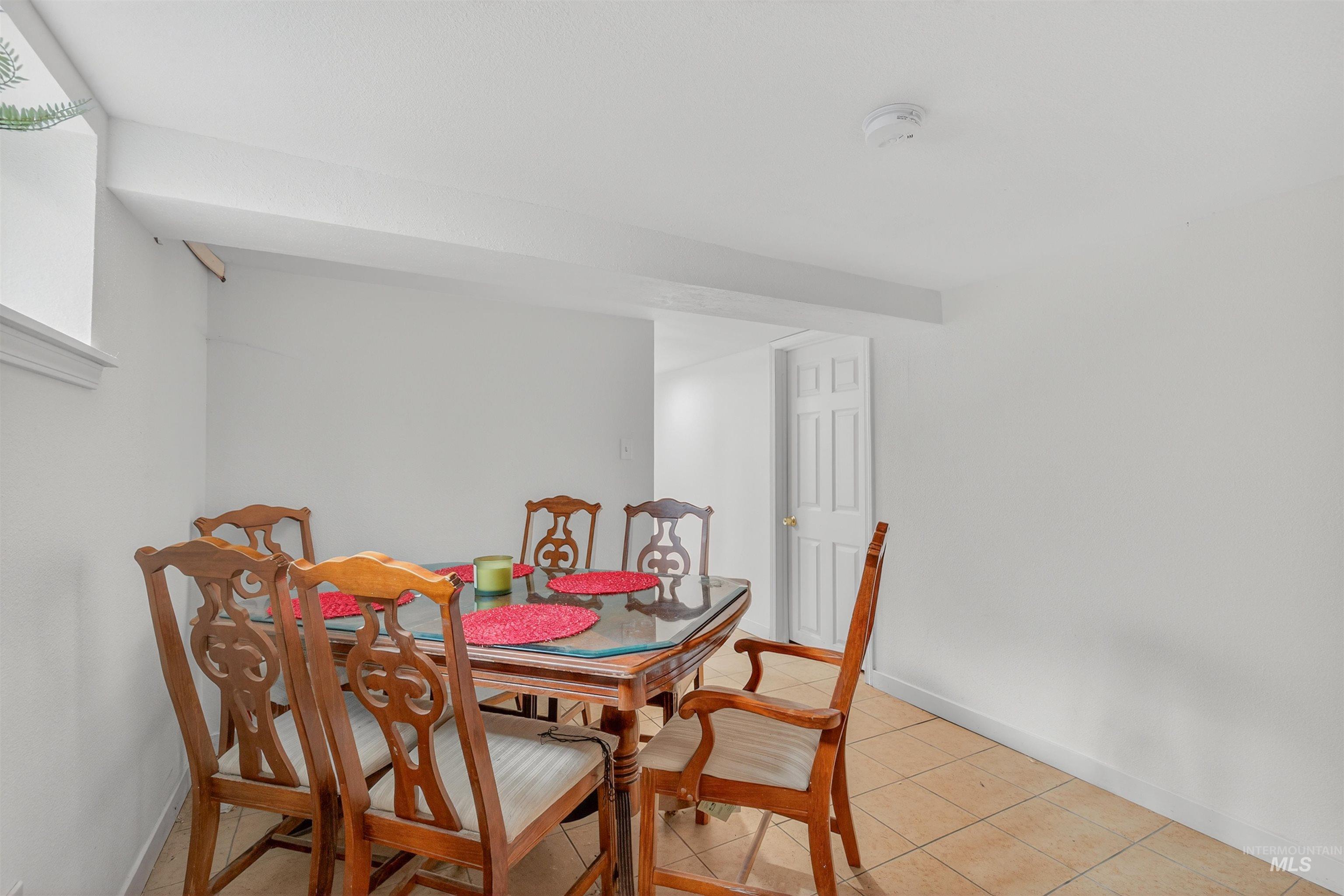 Dining space with light tile patterned floors and baseboards