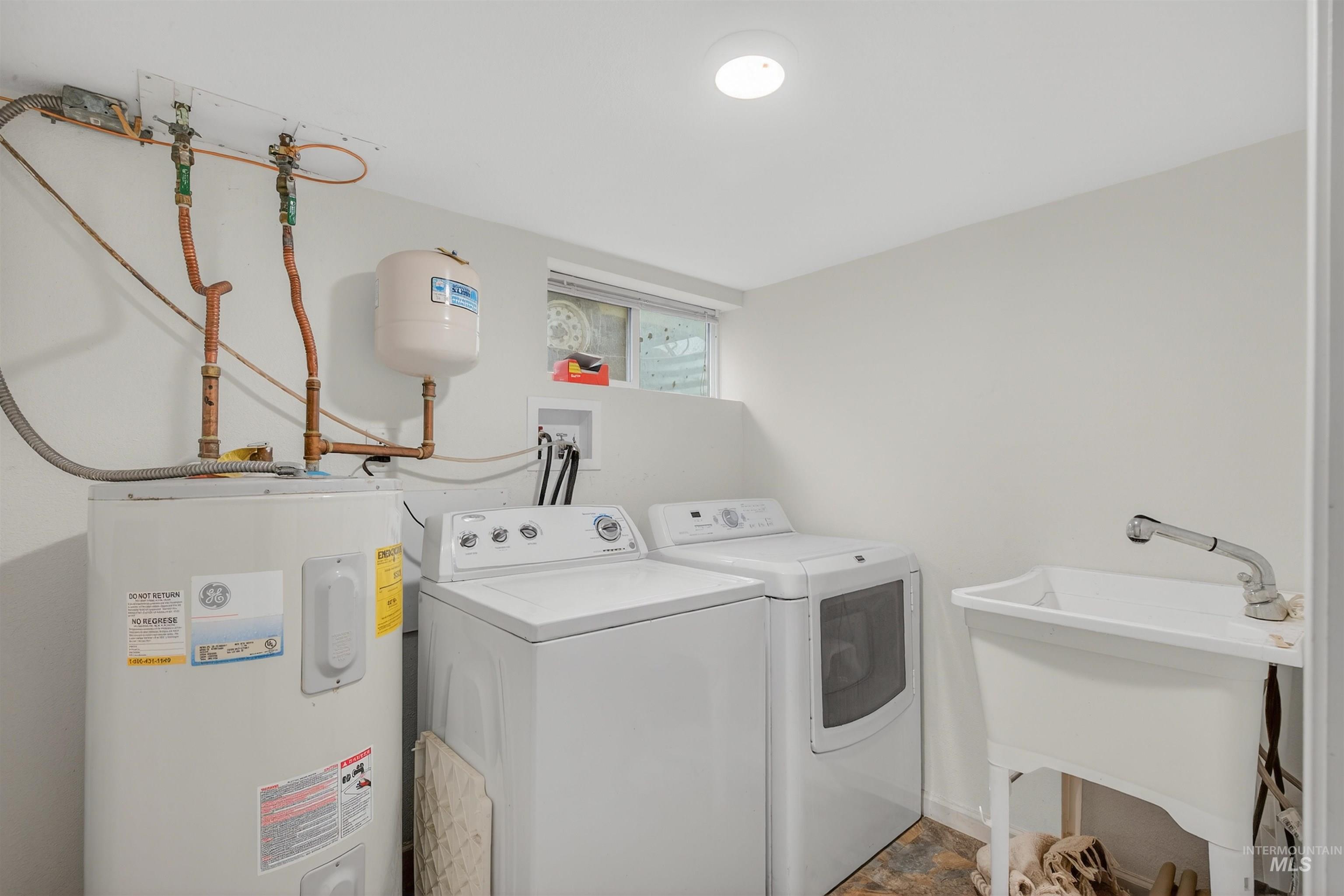 Laundry room featuring water heater and independent washer and dryer