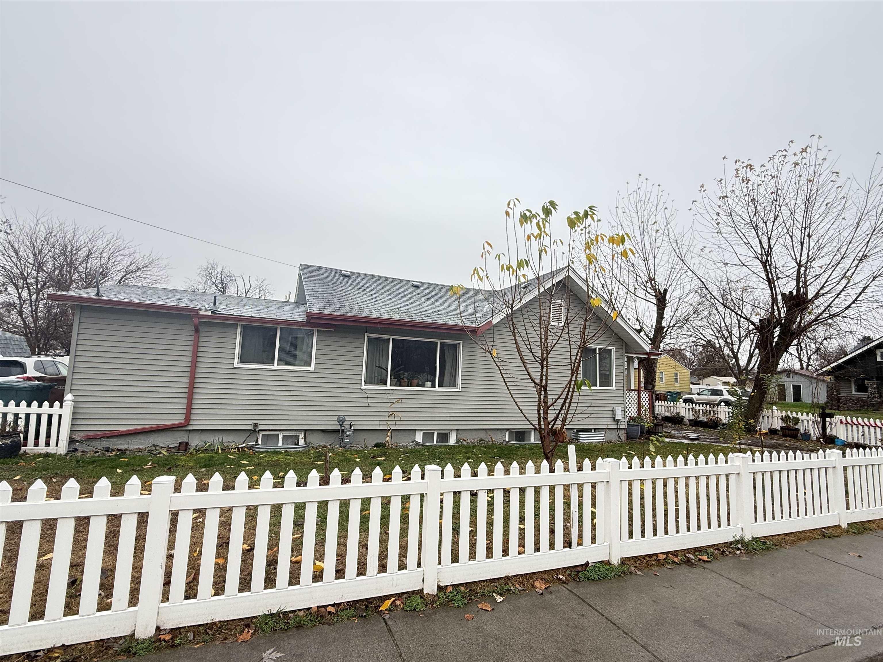 View of front of home featuring a fenced front yard and a shingled roof