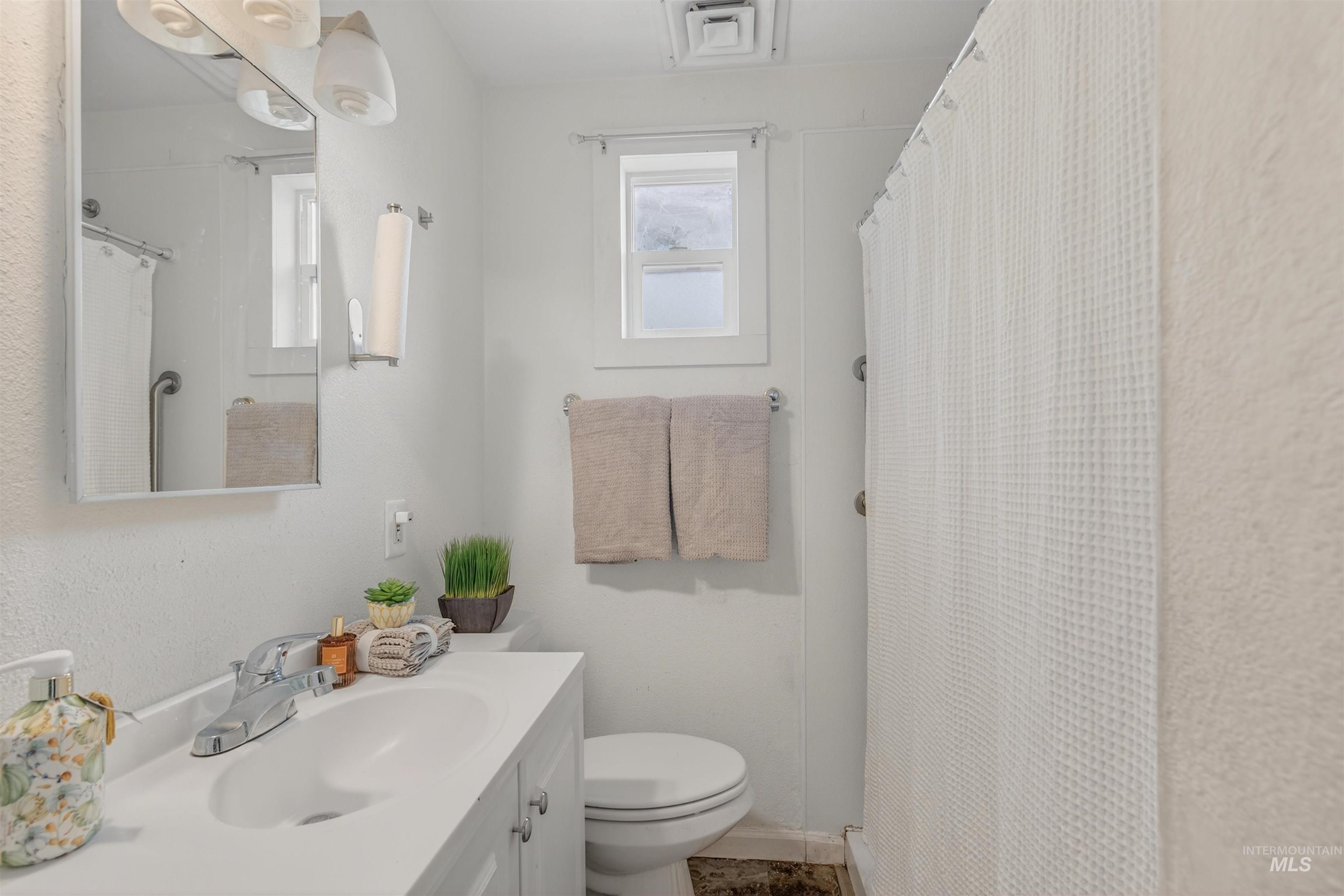 Bathroom featuring vanity, curtained shower, and a textured wall