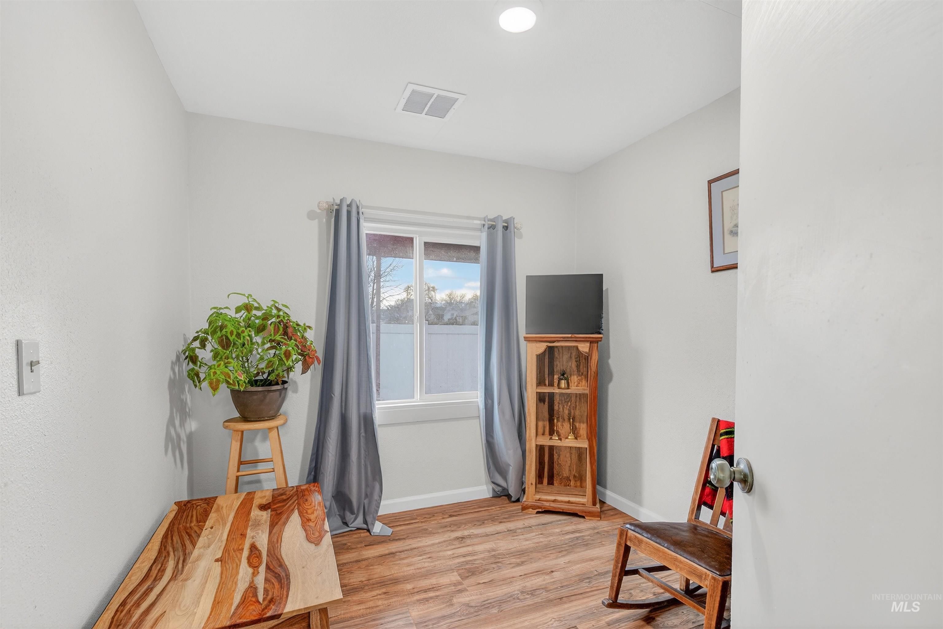Sitting room with light wood-style floors and baseboards
