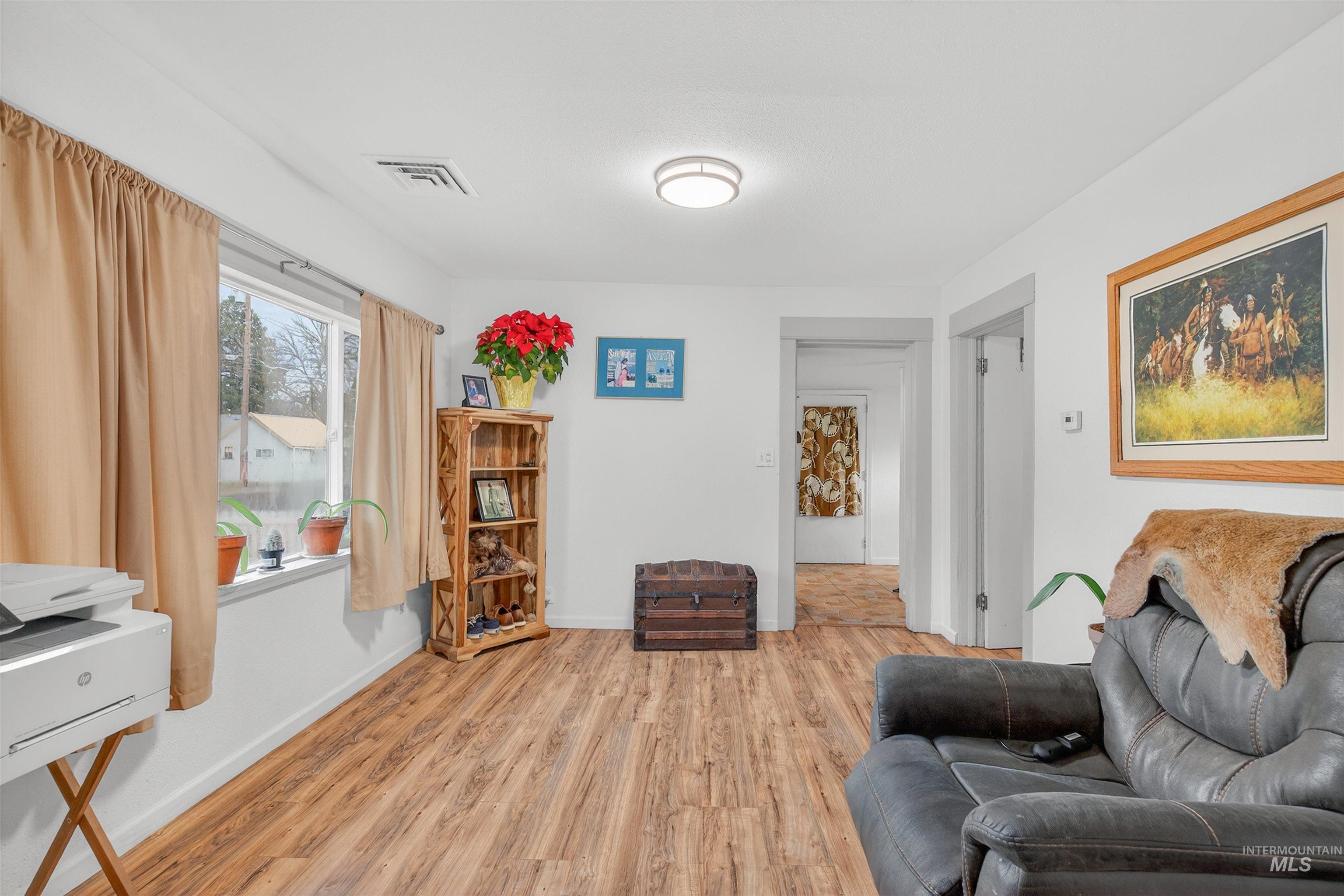 Living room featuring light wood-type flooring and baseboards