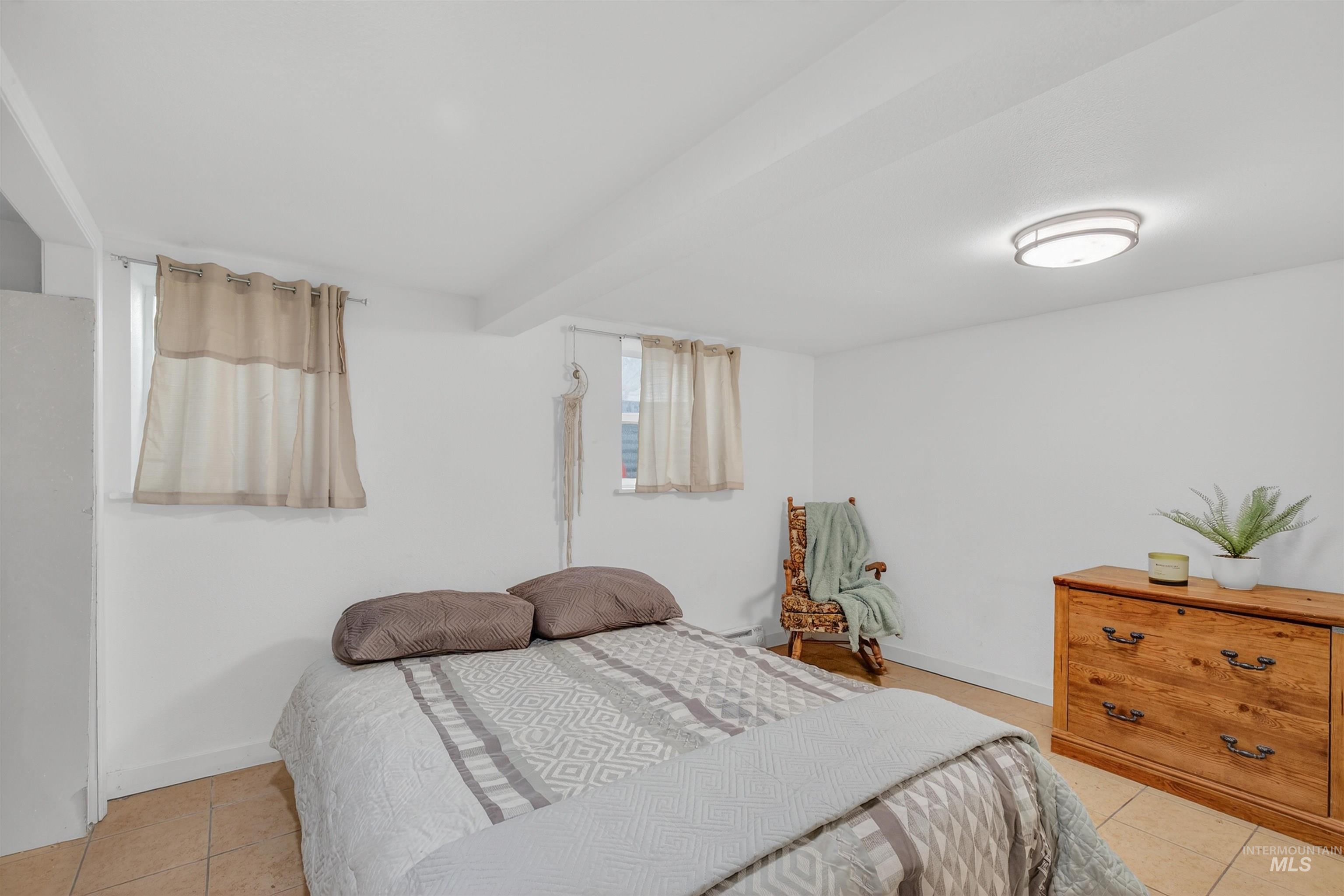 Bedroom featuring light tile patterned flooring and baseboards